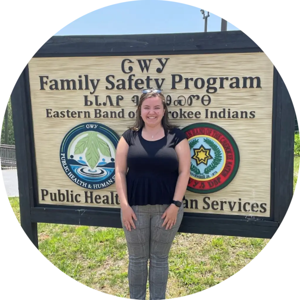 Student standing in front of Family Safety Program sign in Cherokee